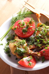 Roasted duck legs with tomato and herbs with wooden cutlery