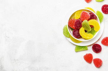 Multicolored marmalade in sugar, light background, top view