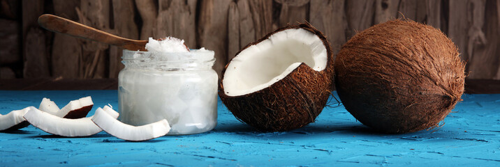 coconut oil and fresh coconuts on blue background