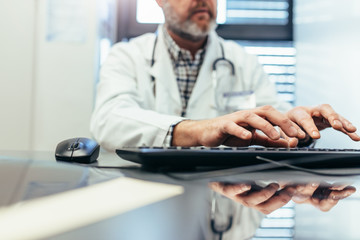 Medical professional using computer keyboard in clinic.