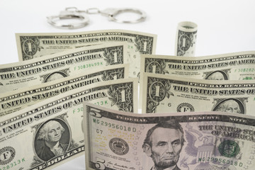 One dollar banknotes on table with the handcuffs