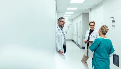 Fotobehang Medical team discussing in corridor at hospital © Jacob Lund