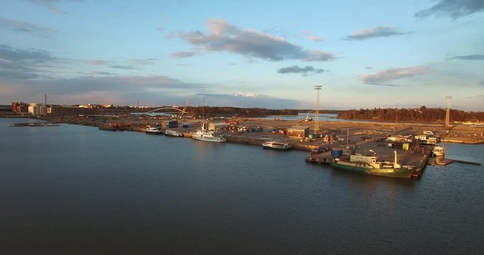4K aerial view drone footage of Helsinki harbour area, boats, sheds and crans and urban city skyline view in the capital of Finland, northern Europe