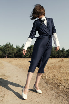 young woman with a coat in a rural area
