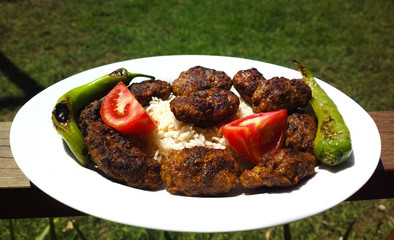 Kofte meatballs on steamed rice in the garden