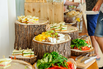 Outside Catering buffet table with a delicious food for guests of the event in rustic style....