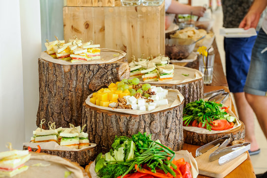 Outside Catering buffet table with a delicious food for guests of the event in rustic style. Service at business meeting, party, weddings. Selective focus, space for text