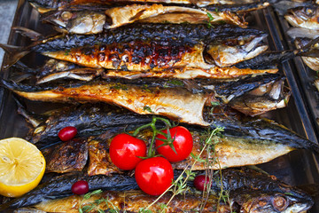 Grilled fish mackerel being served on food stall on open kitchen international food festival event of street food