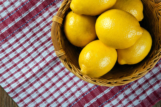 Still life of fresh lemons in a basket and a napkin