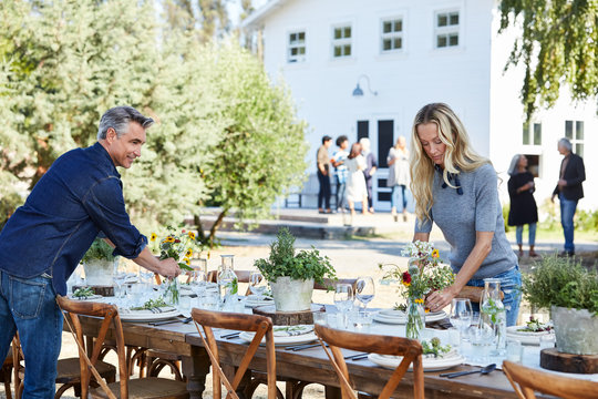 Mature couple setting the table for a farm to table dinner party