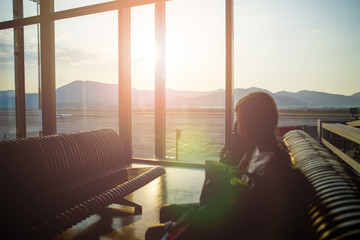 Silhouette of passenger waiting to go aboard at the airport, sunrise background