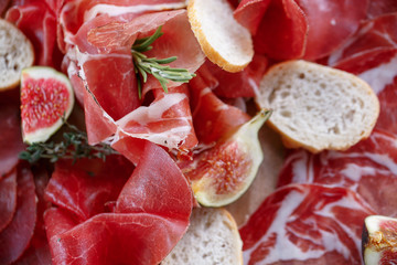Italian antipasti and appetizers. board with slices prosciutto, salami, dried pork, salami ham with herbs.