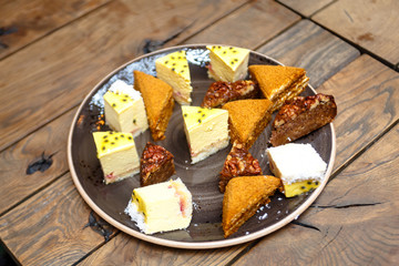 A lot of different pieces of pies and desserts are on the plate.