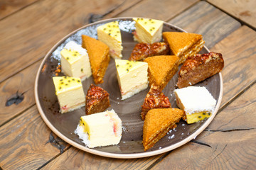 A lot of different pieces of pies and desserts are on the plate.
