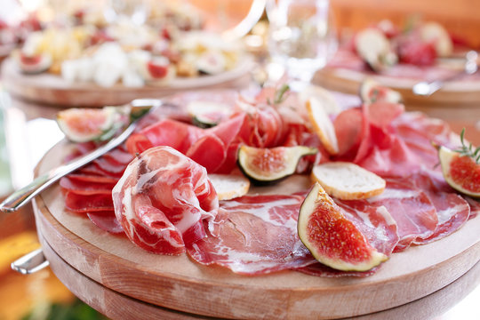Italian antipasti and appetizers. board with slices prosciutto, salami, dried pork, salami ham with herbs.