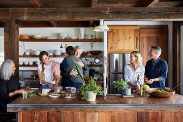 Family greeting dad in the kitchen