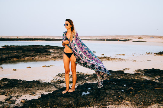 Portrait of young woman on the beach with her mandala towel