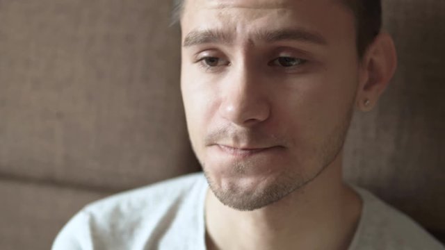 Close up video of a tired sleepy young man rubs his eyes.  People stock footage shot. 
