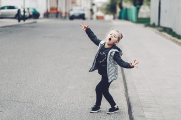 Funny little girl with cat ears posing outdoor with her hands up