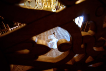 Beauty bride in bridal gown with lace veil indoors