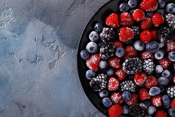 Assorted frozen berries with space for text, top view