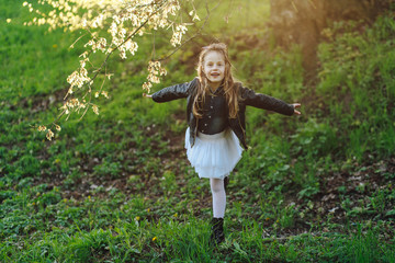 trendy emotional little girl in black boots. Funny girl with open mouth looking at camera