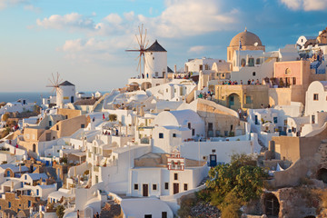 Fototapeta na wymiar SANTORINI, GREECE - OCTOBER 4, 2015: The look to part of Oia with the windmills in evening light.