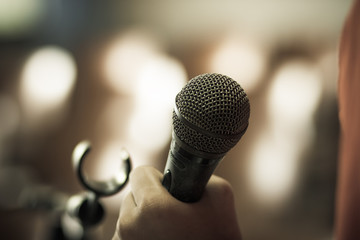 blurred of hands holding businesspeople speech and speaking with microphones in seminar , talking...