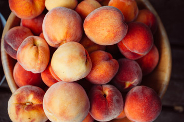 A group of ripe peaches in a bowl