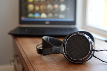 Obraz na płótnie Canvas Audiophile planar headphones with Laptop PC computer in background