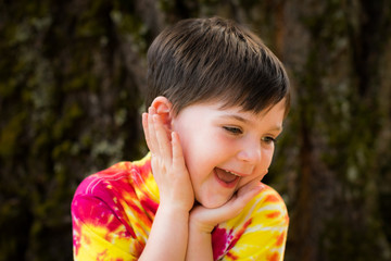 Smiling child looking down in colorful shirt
