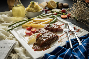 steak with vegetables, fries and barbecue sauce