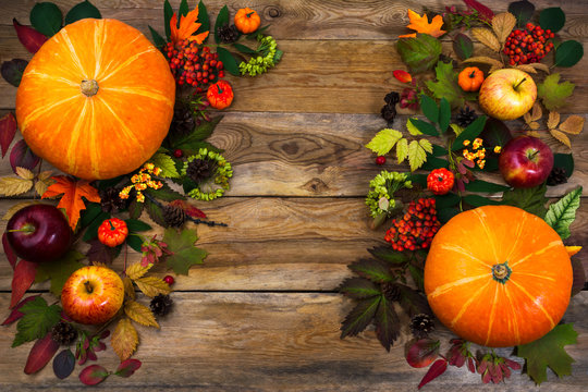 Thanksgiving greeting with leaves and pumpkin on wooden table