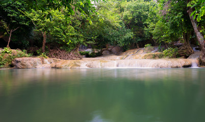 Waterfall in the jungle with lush greenery in the rainy season.