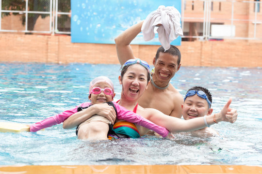 Happy family, active mother, daughter and sun having fun in a swimming pool
