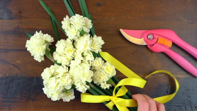4k Spring overhead with Erlicheer jonquil daffodils on a rustic wood table background, real time.