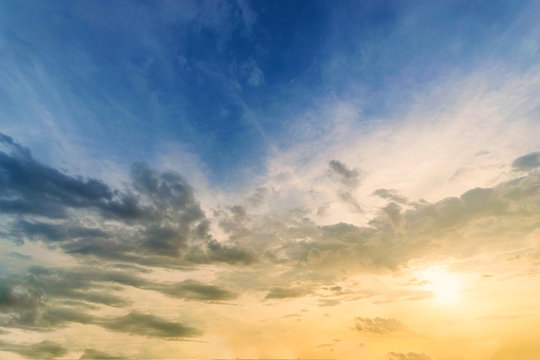 Sky background at sunset,Sky blue and orange light of the sun through the clouds in the sky survive