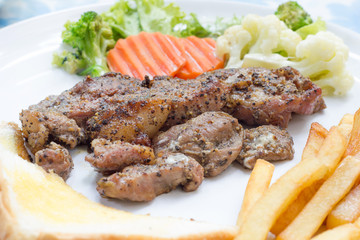 Grilled steak with french fries and vegetables and toast
