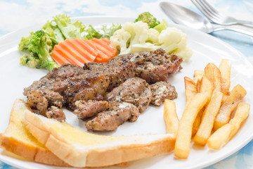 Grilled steak with french fries and vegetables and toast