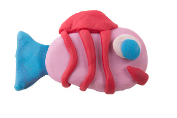 children's hands make fish from clay on the white background