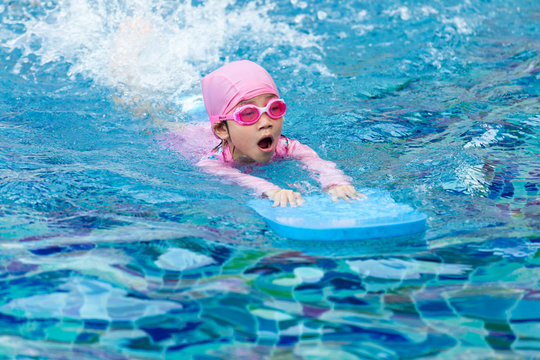 Little girl swimming in pool.