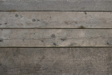 Wood planks with a strip of concrete at the top