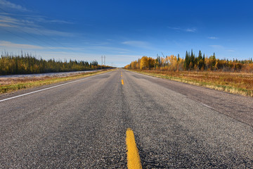 Highway in Northern Saskatchewan, Canada by Meadow Lake in Autumn.