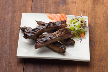 Roasted sliced barbecue pork ribs, focus on sliced meat