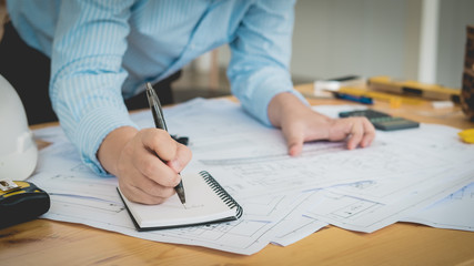 Architect or planner working on drawings for construction plans at a table