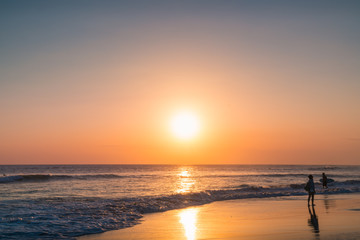 Water Sunset Background. Clear Tropical Island View with Young Woman. Sunset Waves and Amazing Landscape Ocean. Orange Ocean Beach. Sun rays in a Colorful Sunset Background. Beautiful Girl