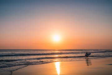 Fototapeta na wymiar Sunset Background Ocean. Tropical Sunlight and Summer Sunset View. Colorful Background Sunset. Blue Waves near sea Resort. Sea sunset Background. Colorful Beach with Surfers on the Horizon. Landscape