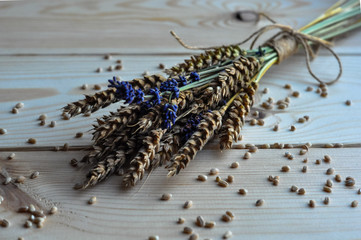 Bouquet of peas of ripe wheat and lavender with grains on a wooden table