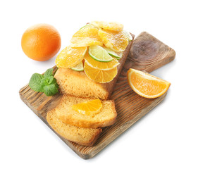 Cutting board with delicious sliced citrus cake and fruits on white background