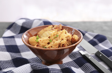 Bowl with tasty baked potato, bacon and cheese on table